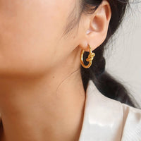 18K gold plated knot earrings worn close up Saudi Arabia Jewelique